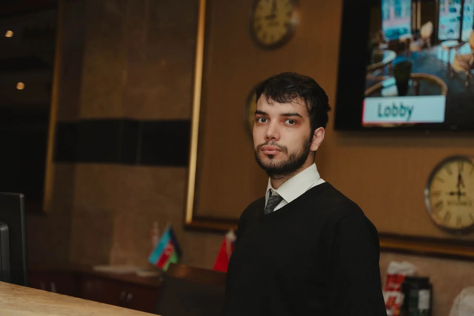 A hotel receptionist standing behind the reception desk.